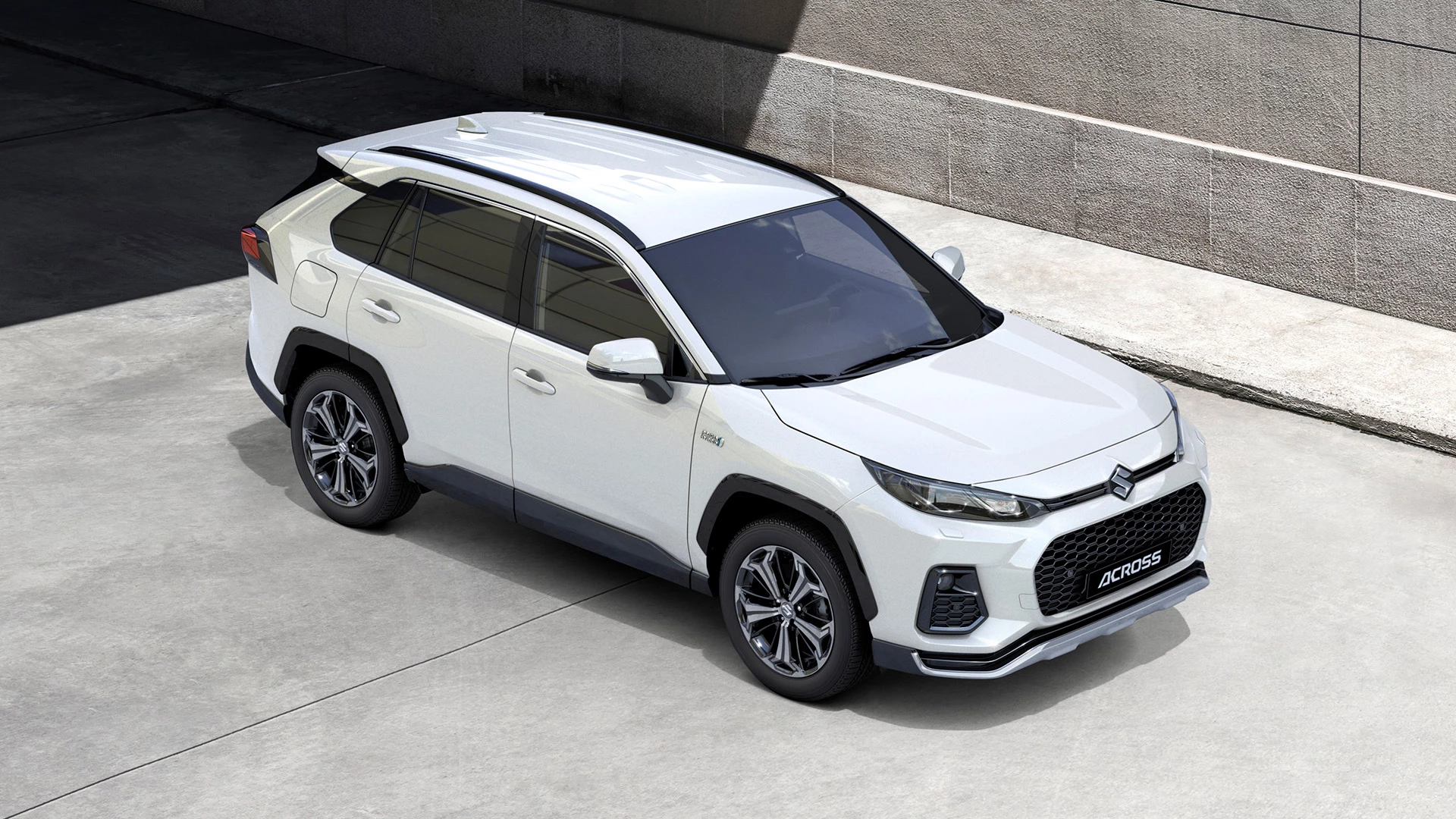 High-angle view of the Suzuki Across parked near a wall, illustrating the vehicle's front and rear parking distance sensors.