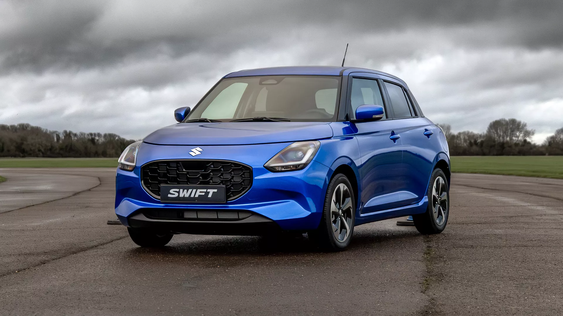 Front three-quarter view of the Suzuki Swift parked outdoors, highlighting its sculpted body lines and dynamic exterior styling