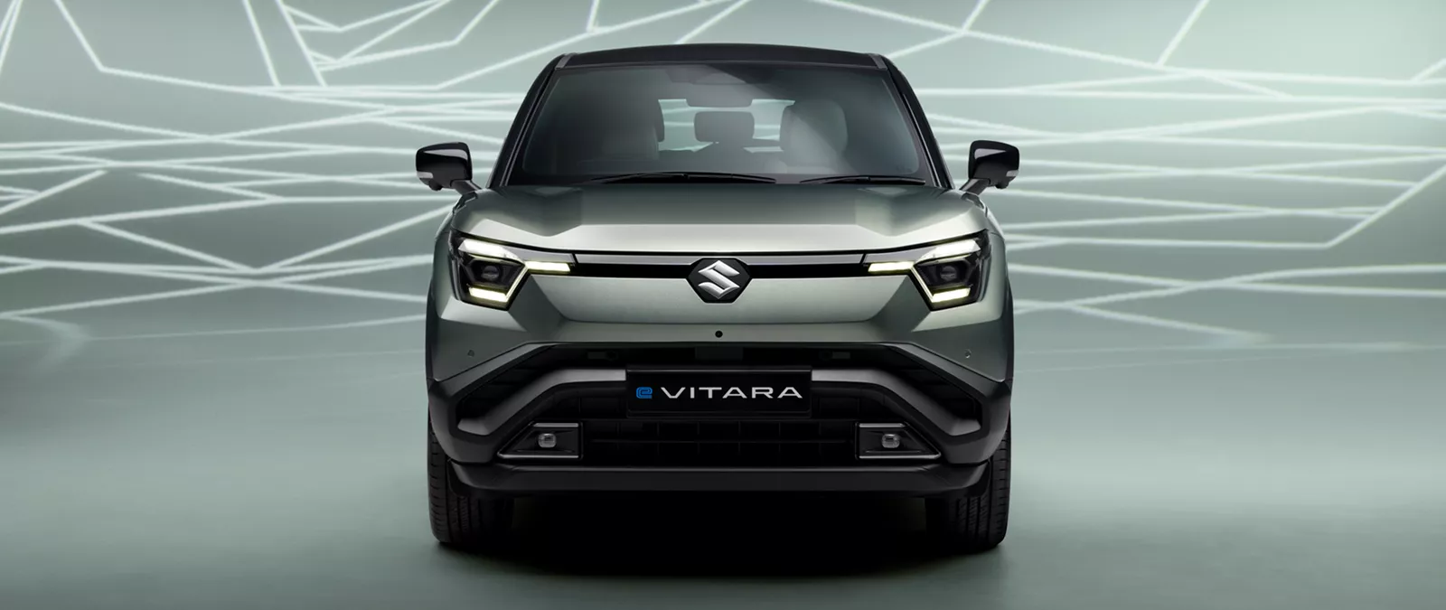 Front view of the Suzuki e Vitara in Land Breeze Green Pearl Metallic, showcasing LED headlights and bold grille