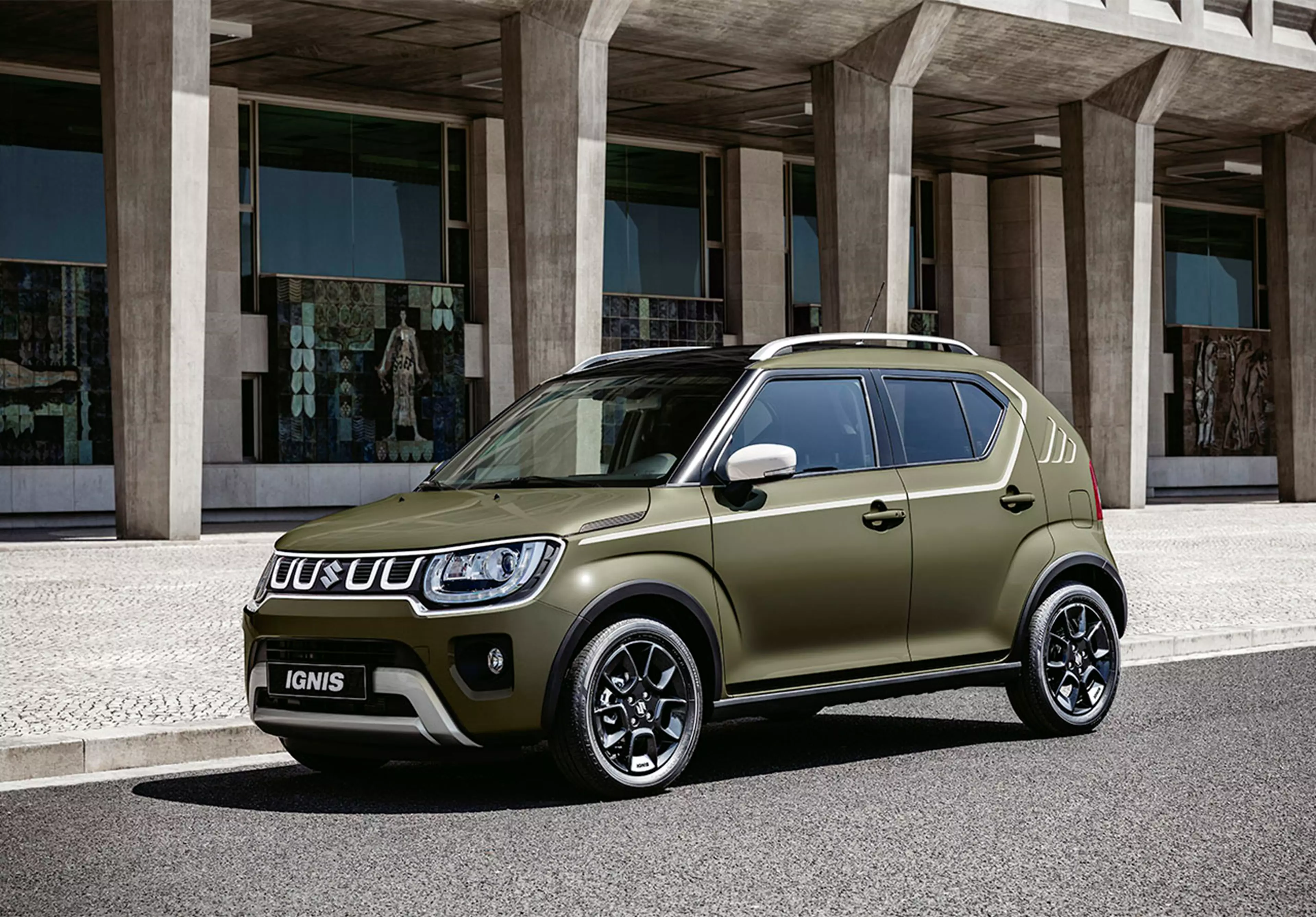 Khaki Suzuki Ignis parked in front of a building