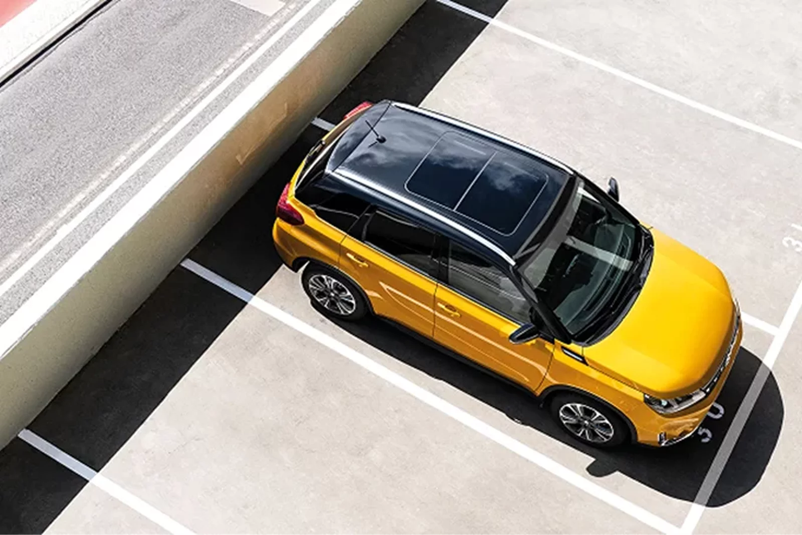 Top view of a yellow Suzuki Vitara parked in a car park