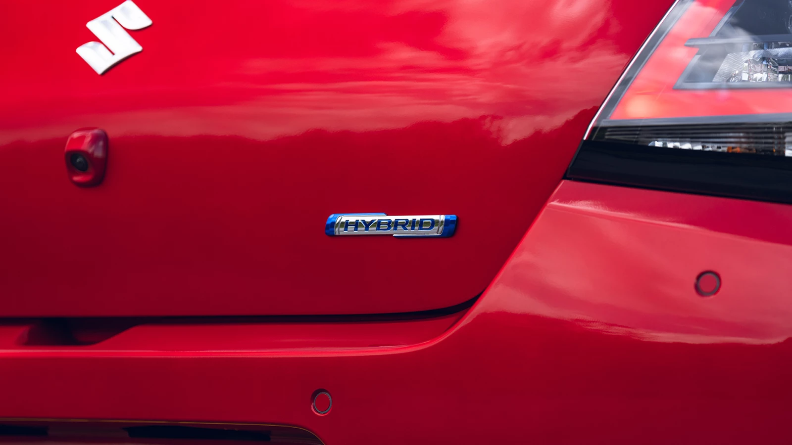 Close-up of the Suzuki swift rear tailgate showing the Hybrid badge beneath the tail light, highlighting its electrified drivetrain.