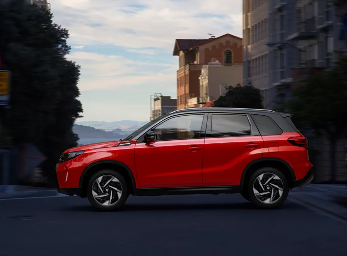 Bright red Suzuki Vitara side view city