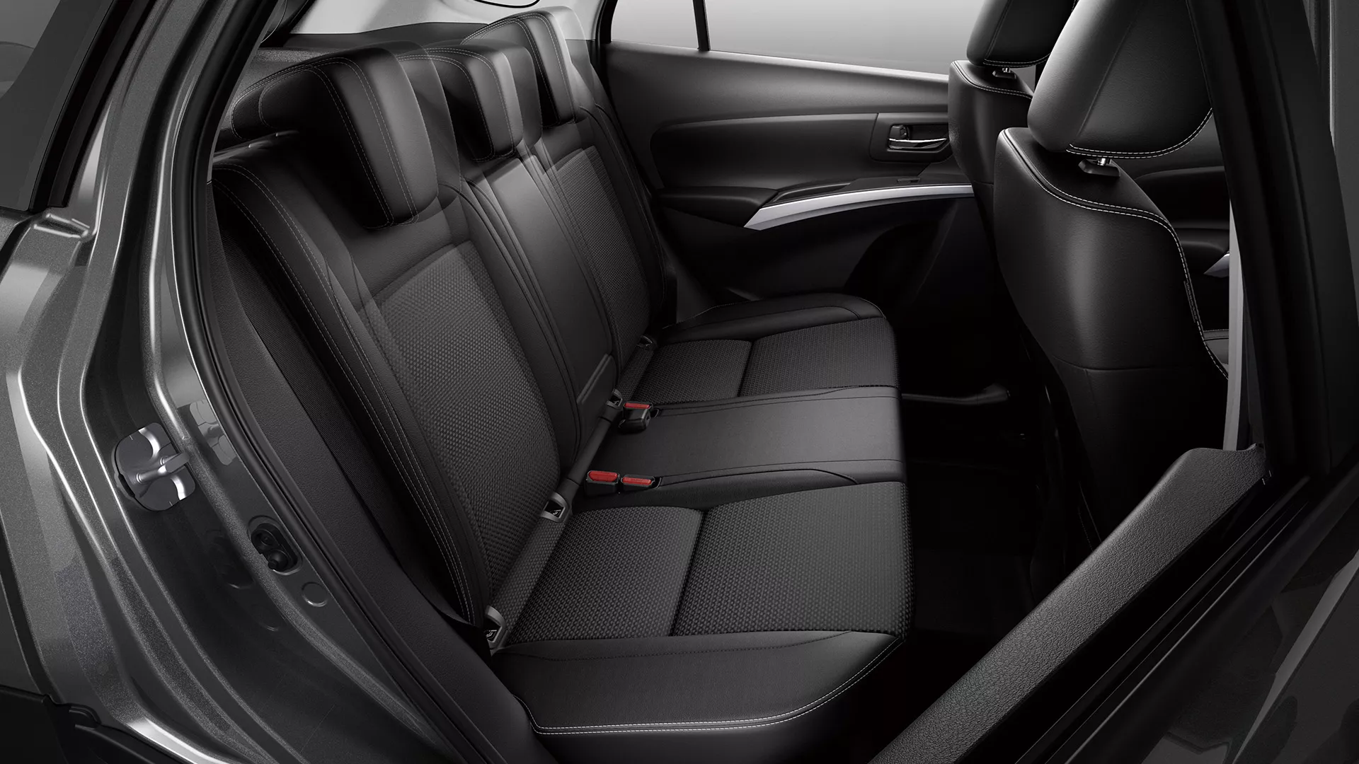 Interior view of the Suzuki S-Cross rear passenger seats, showcasing black fabric upholstery, three headrests, and spacious legroom.