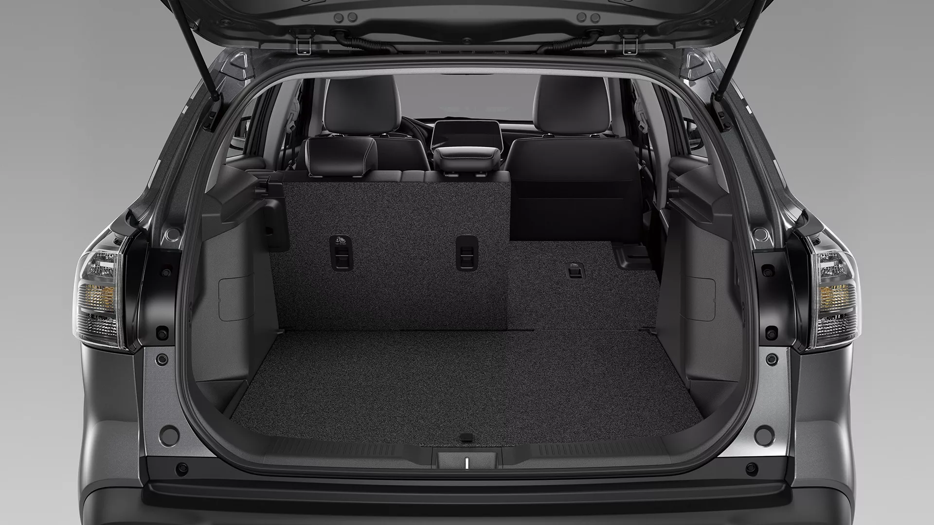 Rear view of the Suzuki S-Cross boot with one side of the 60:40 split-folding rear seats lowered, showing versatile cargo and passenger space configuration.