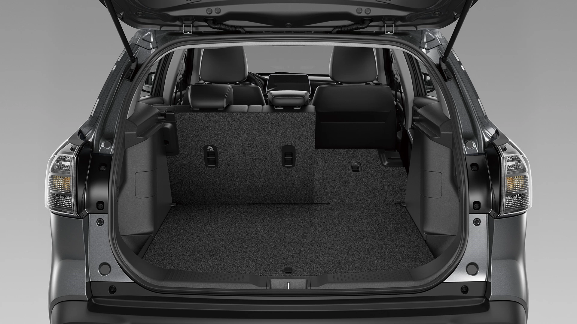 Rear view of the Suzuki S-Cross boot with one side of the 60:40 split-folding rear seats lowered, showing versatile cargo and passenger space configuration.