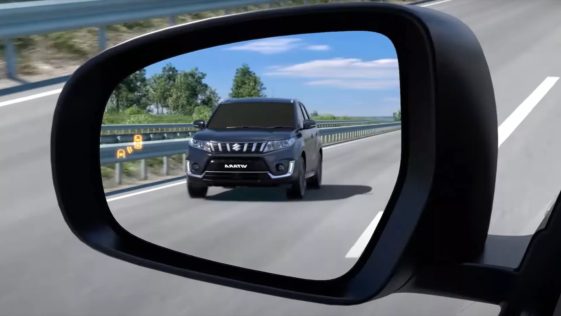 Close-up of the Suzuki Vitara wing mirror displaying the illuminated Blind Spot Monitor alert symbol and heated mirror icon.