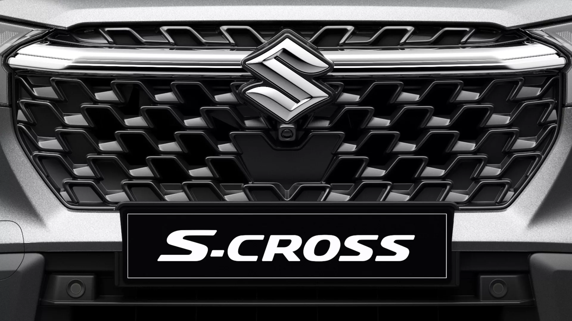 Close-up of Suzuki S-Cross front grille with bold honeycomb design and central Suzuki emblem.