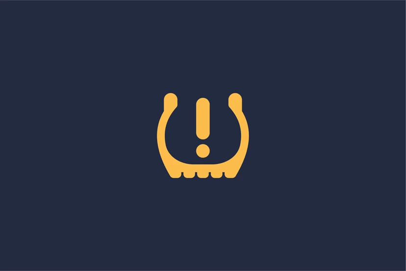 Low tyre pressure warning lights illuminated on a car dashboard.