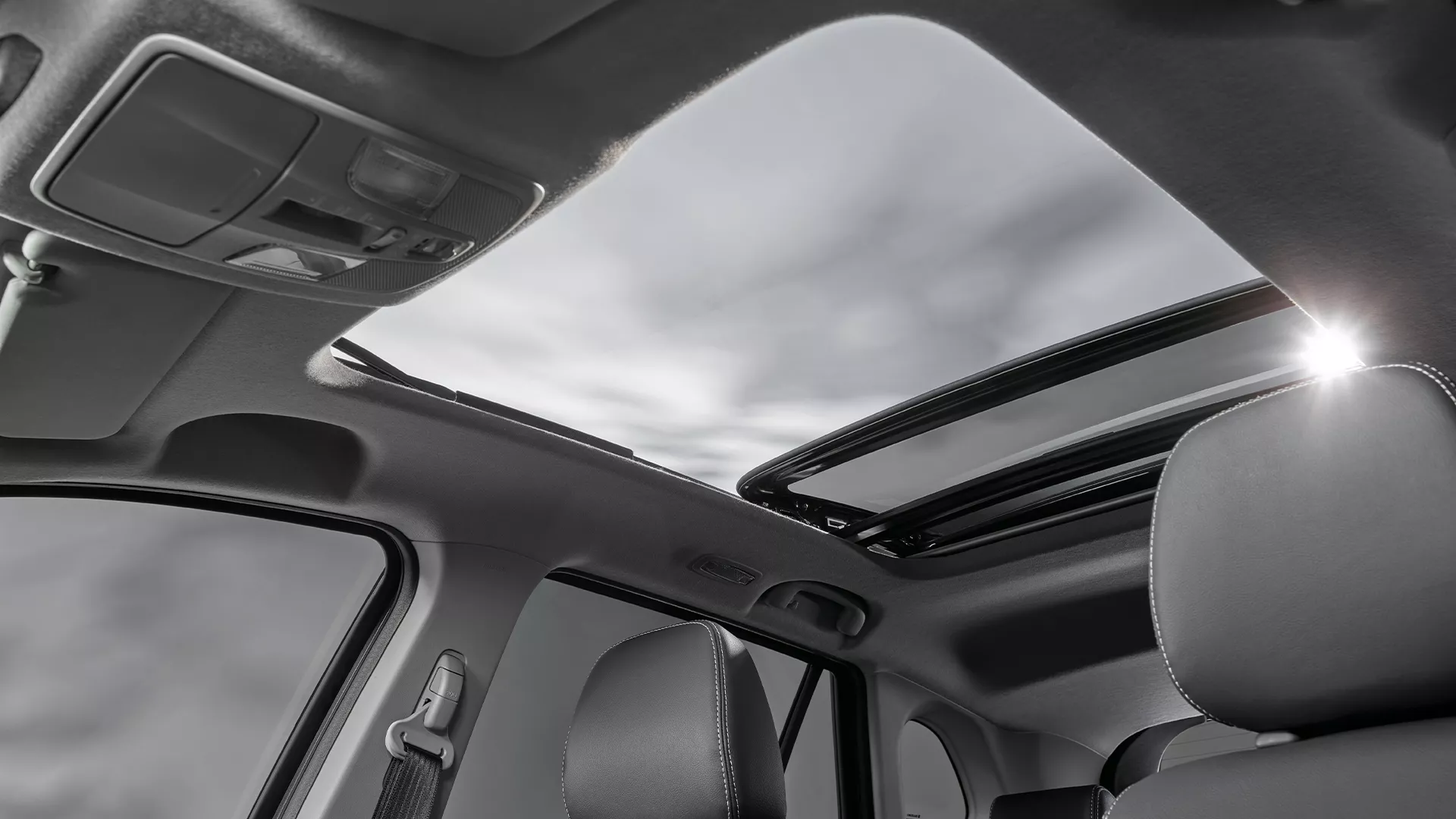 Interior view of the Suzuki S-Cross featuring a panoramic sunroof, allowing natural light into the cabin and enhancing the spacious feel for front and rear passengers.
