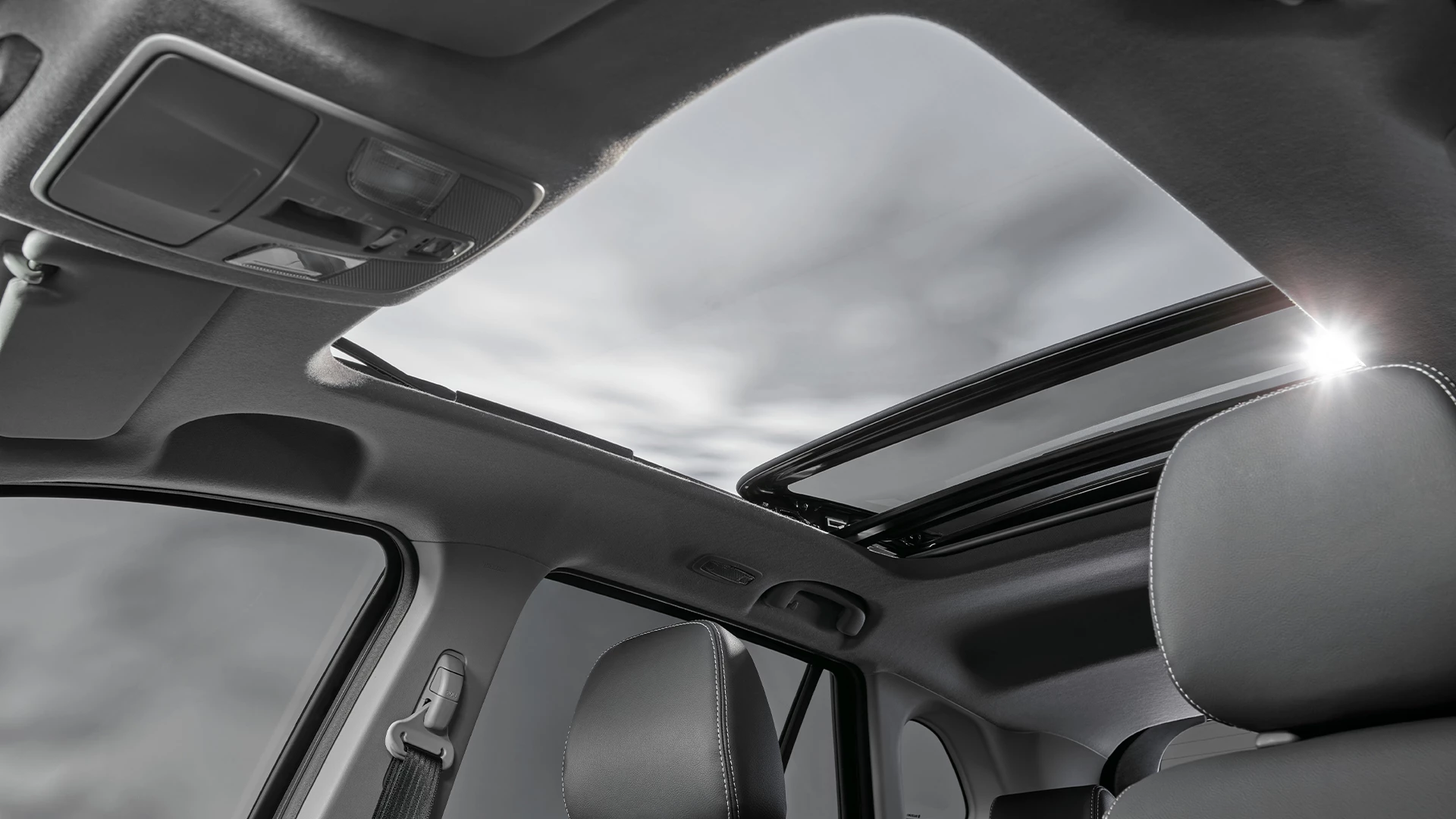 Interior view of the Suzuki S-Cross featuring a panoramic sunroof, allowing natural light into the cabin and enhancing the spacious feel for front and rear passengers.