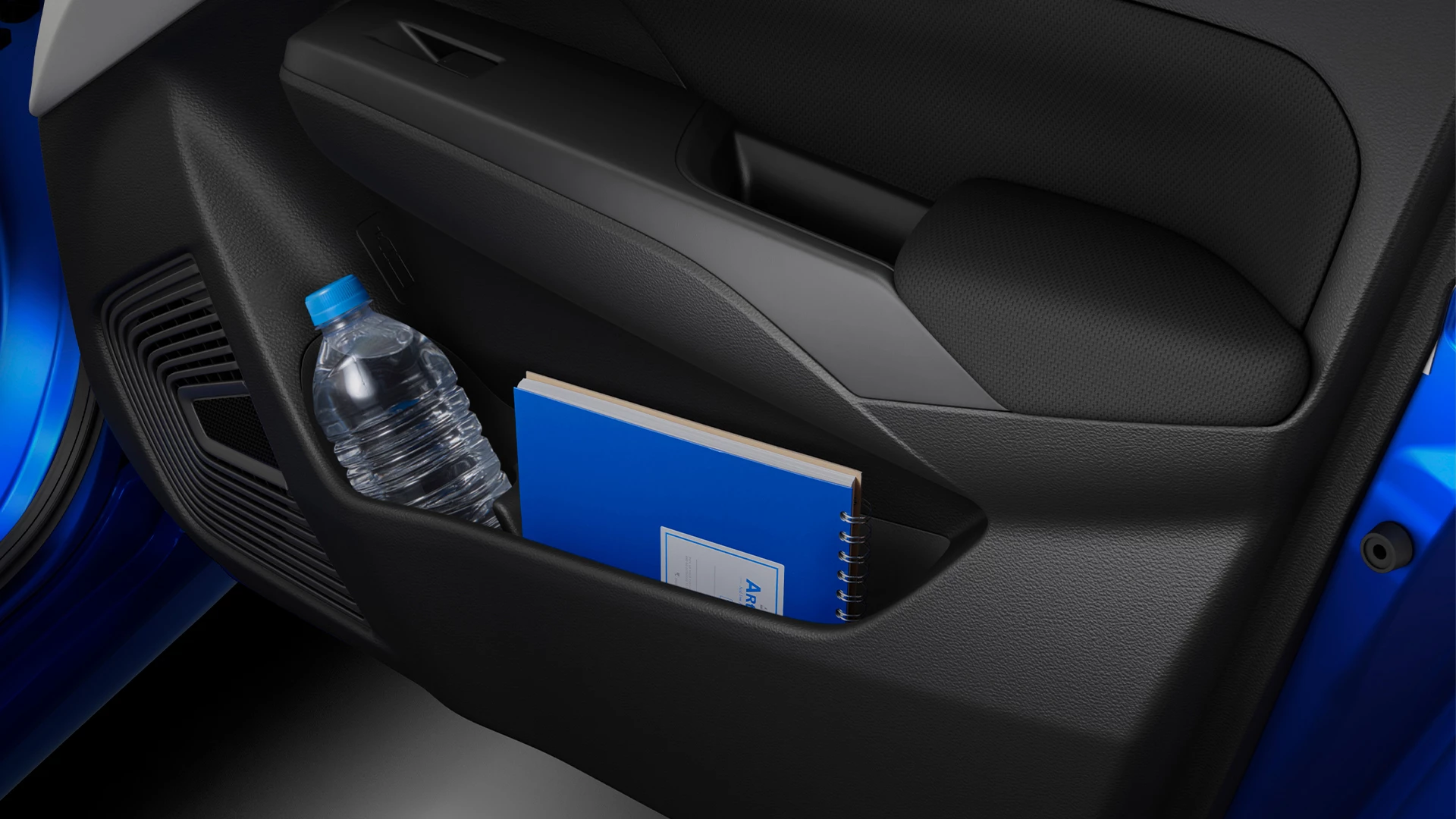 Suzuki Swift’s interior door storage compartment holding a water bottle and blue notebook