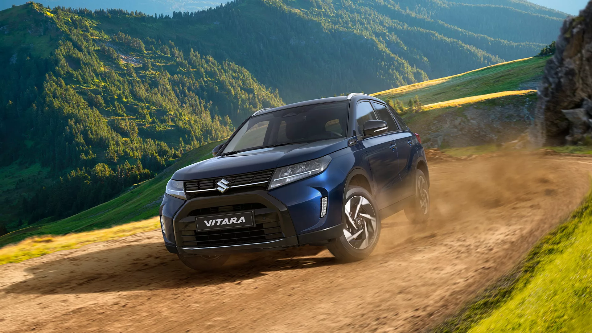 Suzuki Vitara navigating a rugged dirt trail in the mountains, demonstrating ALLGRIP 4-wheel drive capability in an off-road environment.