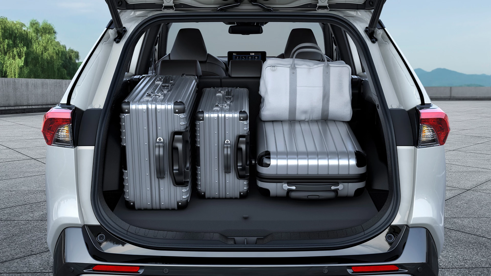 Rear view of the Suzuki Across boot loaded with multiple suitcases, highlighting its generous luggage capacity and practical storage space for travel and everyday use.