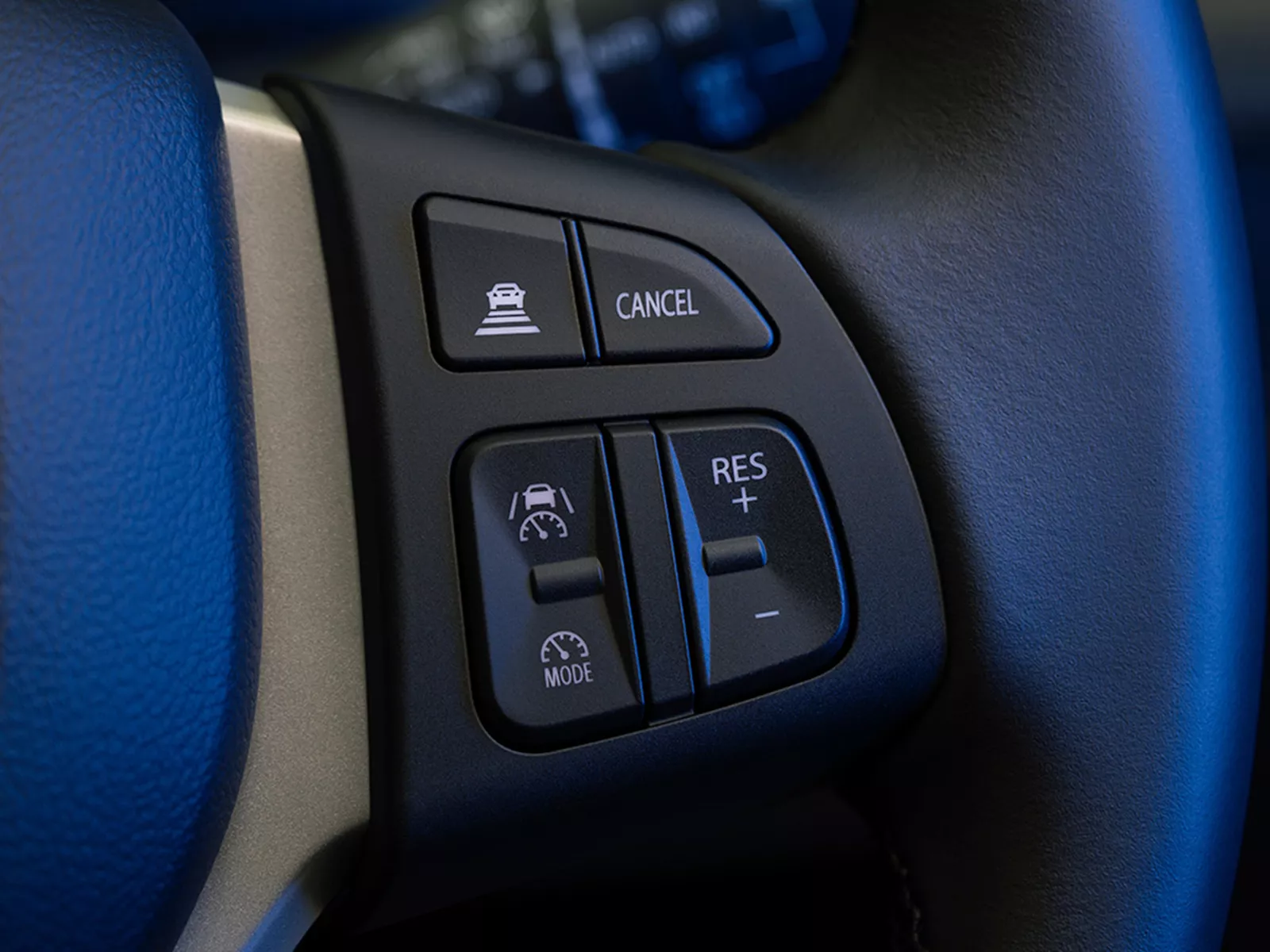 Close-up of the Suzuki Vitara steering wheel controls, featuring cruise control and adaptive driving assistance buttons.
