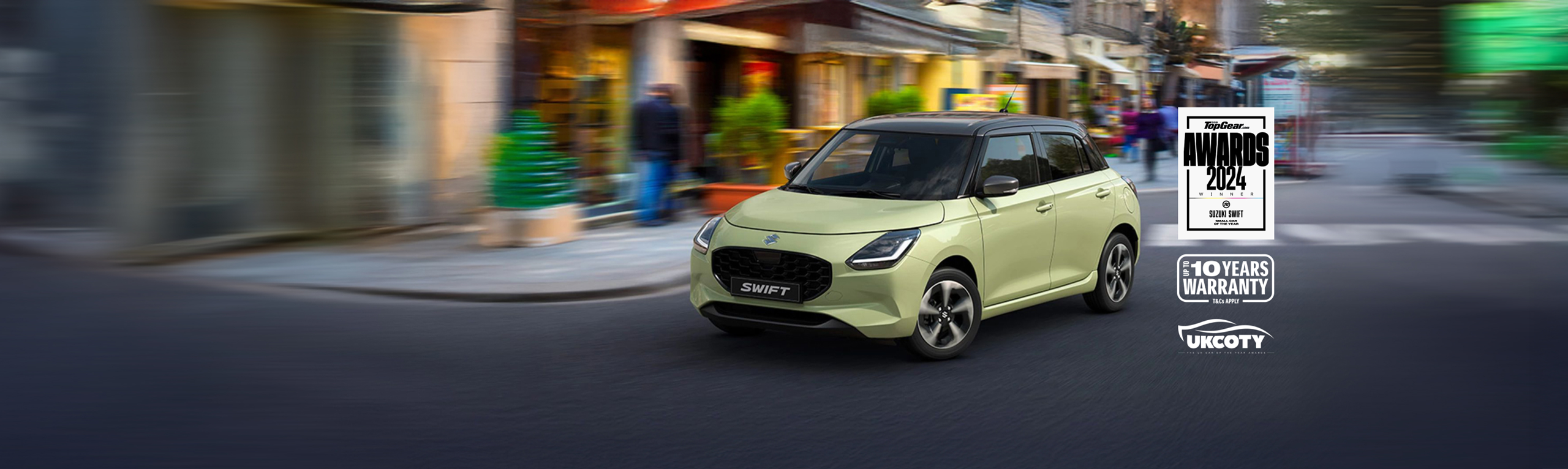 Suzuki Swift driving through a vibrant city street, showcasing its modern design and Top Gear Award badge with up to 10 years warranty.