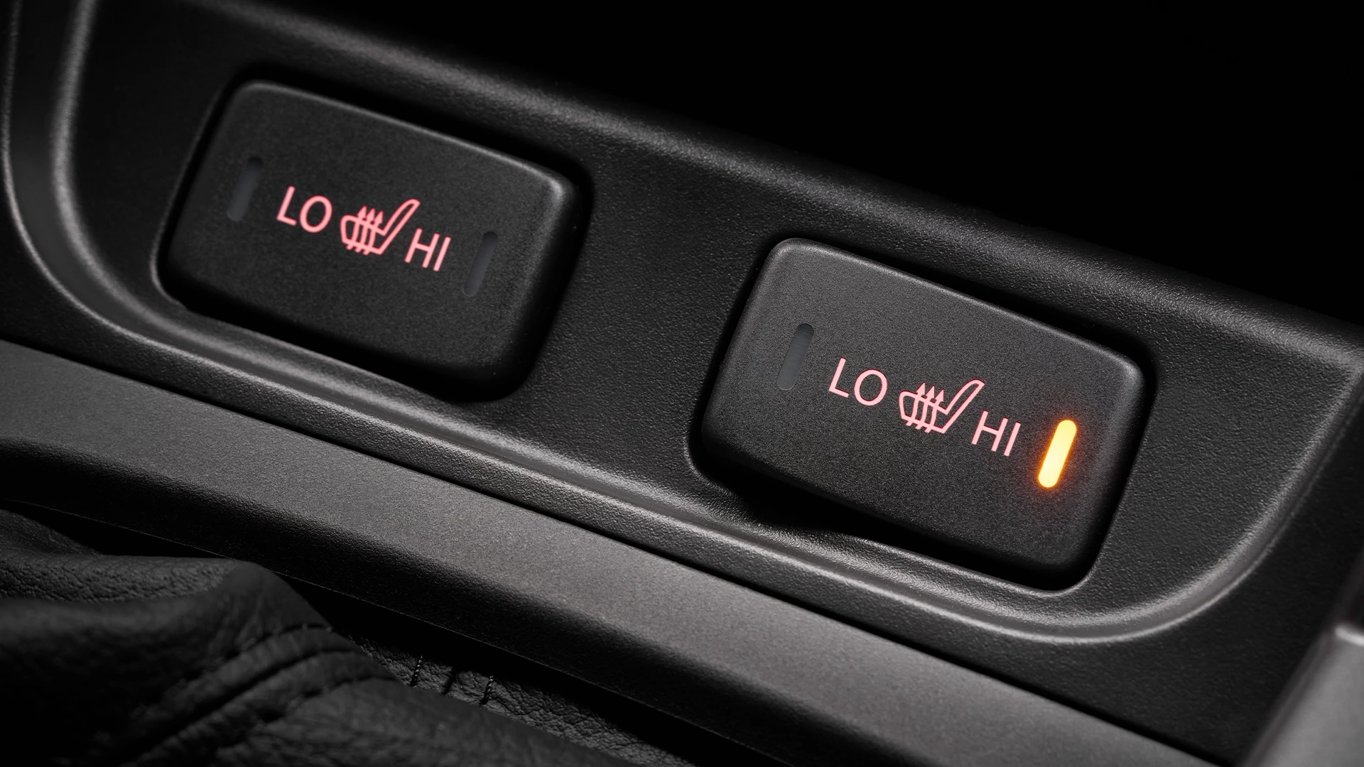 Close-up of Suzuki S-Cross heated seat controls showing illuminated high setting, with LO and HI adjustment options for enhanced comfort.